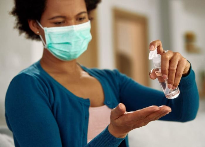 Woman applying antimicrobial hand sanitizer.